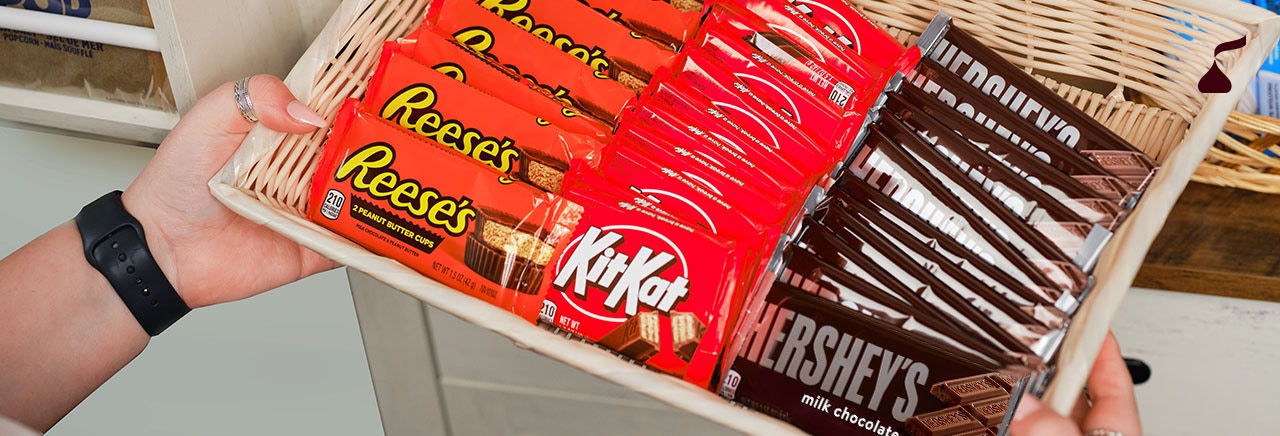 Person holding a basket of candy bars